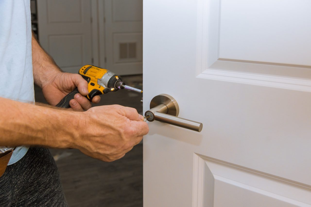 Locksmith fitting a door handle and lock